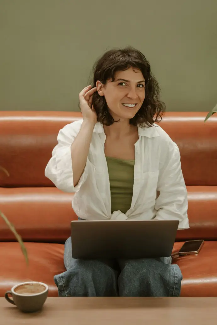 a woman sitting on a couch using a laptop computer